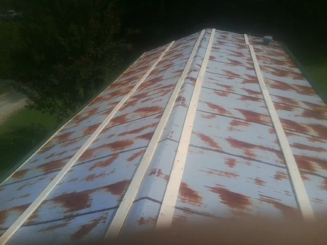 Rusted metal roof panels with new wood purlins before replacement — Storm Damage Roof Repair in Three Springs by Roofing Brothers