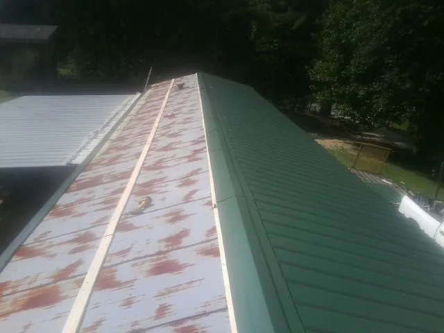 Old rusted panels beside newly installed green metal roofing — Wind Damage Roof Repair by Roofing Brothers in Three Springs